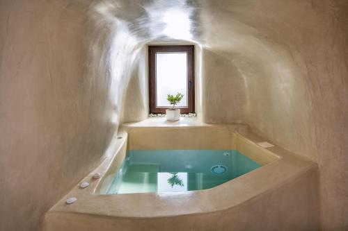 梅加洛克里Aegean Mist Luxury Suites的带浴缸和窗户的浴室