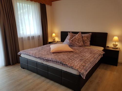 格雷兴施内沃谷尔木屋公寓的一间卧室配有一张大床、枕头和两盏灯。