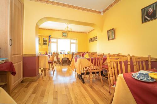 韦斯特波特博特拉住宿加早餐旅馆的餐厅设有桌椅和黄色的墙壁