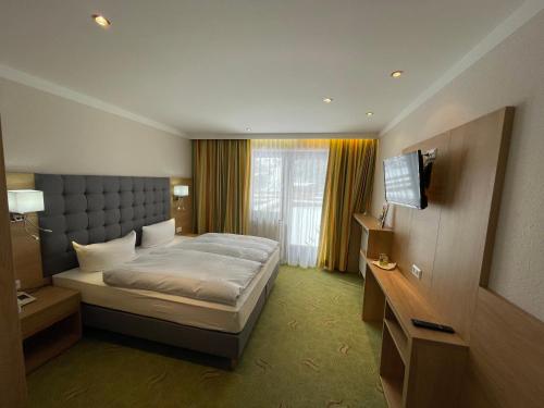 施特格Hotel Styrolerhof的酒店客房,配有床和电视