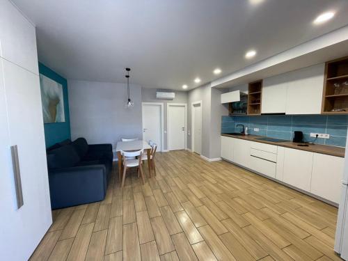卡罗利诺-布加兹Золотой Бугаз, Колоски, апартамент 7/1的厨房以及带蓝色沙发和桌子的客厅。