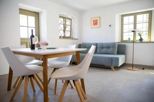 科巴里德Hiša Liza的客厅配有桌子和白色椅子