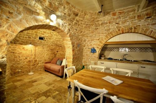 阿尔贝罗贝洛特鲁利普利亚度假旅馆的一间厨房和带石墙的用餐室
