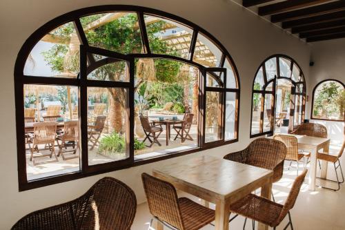 圣埃乌拉利亚La Bohemia del Rio Hostal Boutique-Adults Only的客房设有桌椅和窗户。