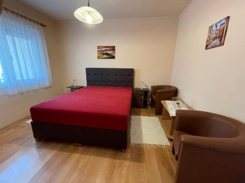 比克Vámos Apartman的一间卧室配有红色的床和一张沙发