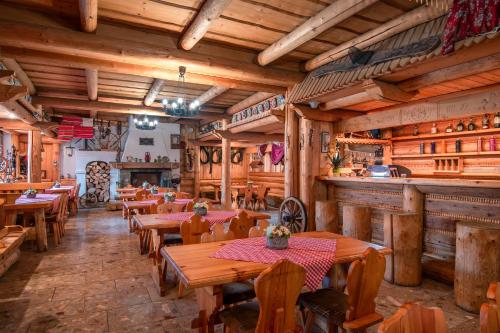 兹蒂尔Penzión Sova Ždiar的一间带木桌椅的餐厅和一间酒吧