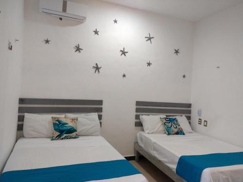 科苏梅尔Casa Esencia的墙上星空间内的两张床