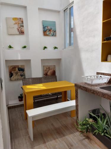 科苏梅尔Casa Esencia的带壁炉的客房内的黄色桌子