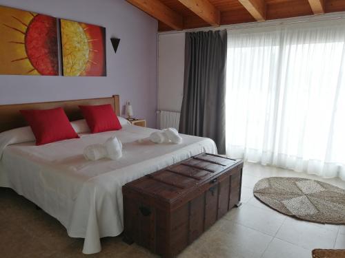 维拉弗兰卡宾纳戴斯Cal Roig Hotel Rural的一间卧室配有一张带红色枕头的大床