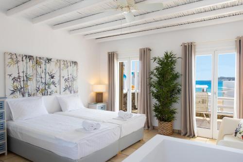 普拉提伊亚洛斯西弗诺斯Miles Away Sifnos - Beachfront House的一间白色的卧室,配有一张床,享有海景