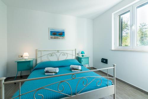 巴斯卡Apartments Garden的一间卧室设有蓝色的床和2个窗户。