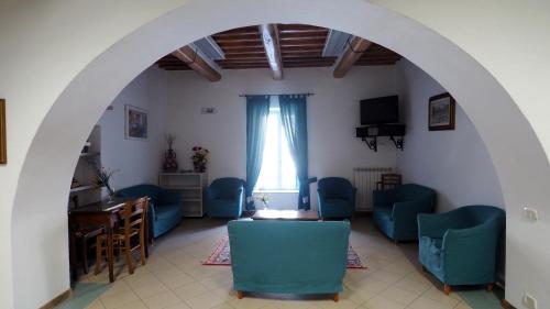 皮蒂利亚诺Residenza Pitigliano的一间设有蓝色椅子、一张桌子和窗户的房间