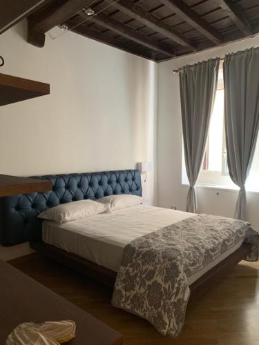 罗马Luxury Roman Holiday Coronari的一间卧室配有一张大床和蓝色床头板
