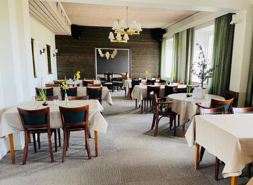 奥萨宫沙卡酒店的用餐室配有桌椅和白色的桌布