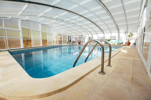 托里什韦德拉什Dii Beach House - Casa de Férias com piscina interior aquecida的一个带天花板的大型游泳池