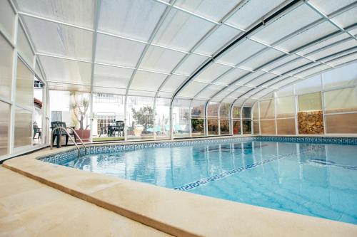 托里什韦德拉什Dii Beach House - Casa de Férias com piscina interior aquecida的一个带天花板的大型游泳池