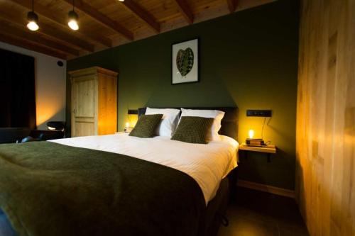 比亨豪特B&B Fagus的一间卧室设有一张大床和绿色的墙壁