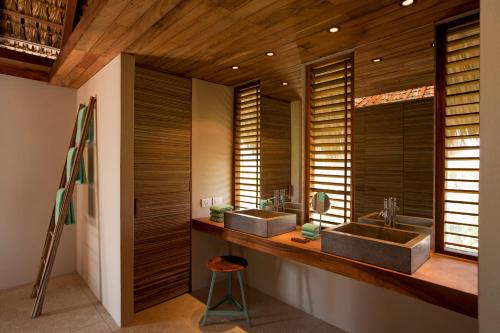 埃斯孔迪多港Hotel Escondido, Puerto Escondido, a Member of Design Hotels - Adults Only的浴室设有木墙和2个水槽。