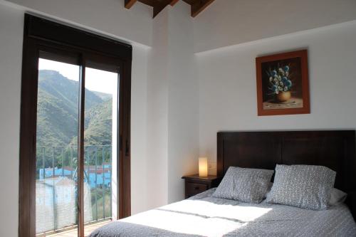 胡斯卡尔Casa el Genal的一间卧室设有一张床和一个大窗户