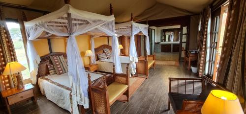 安博塞利乞力马旅行者帐蓬式酒店的一间卧室配有两张床和一张天蓬床。