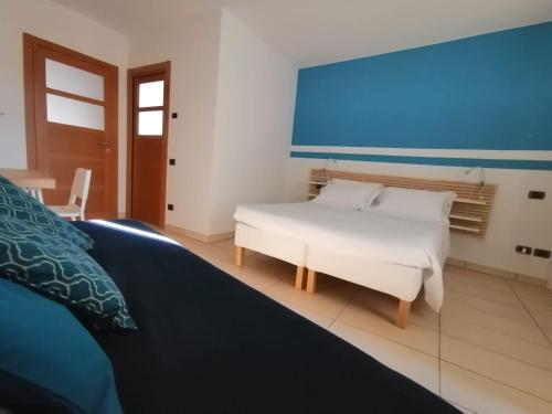 蒙多维Albergo della Posta的卧室配有白色的床和蓝色的墙壁