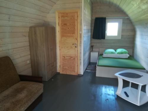 斯文托伊Nameliai Žuvėdra的一间小房间的卧室,配有一张床铺