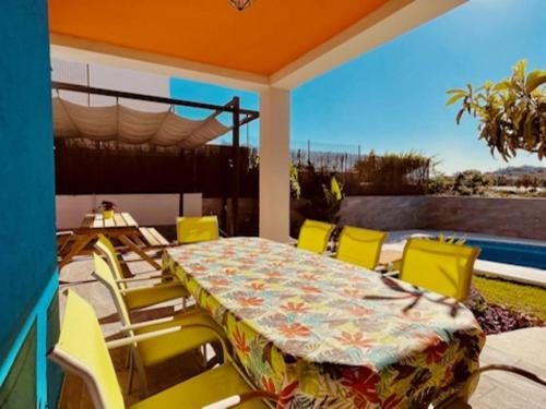 贝纳哈拉菲Holiday Home Los Delfines by Interhome的天井配有桌子和黄色椅子