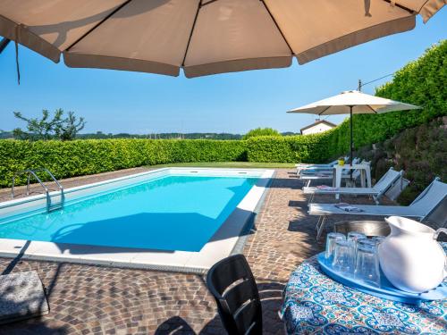 阿斯蒂Holiday Home Marmorito by Interhome的游泳池旁设有遮阳伞和躺椅