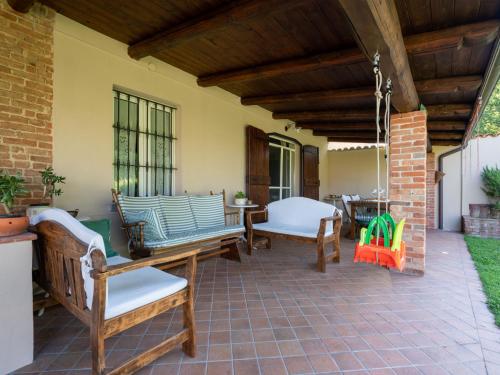 阿斯蒂Holiday Home Marmorito by Interhome的庭院设有摇椅和桌子。