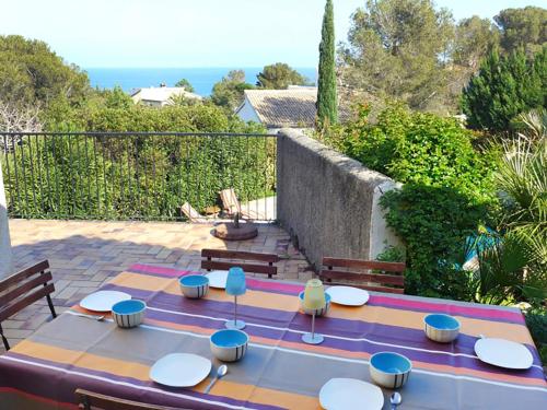 圣艾格夫Villa La Maison du Midi by Interhome的一个带桌椅的庭院和大海