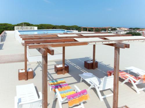 圣温琴佐Apartment Superior-4 by Interhome的屋顶上的木桌和椅子,带游泳池