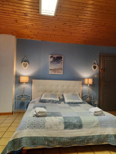 科尔马浪漫中心一室公寓的一间卧室配有一张带蓝色墙壁的大床