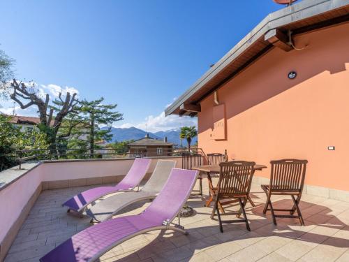 勒威诺Holiday Home Residenza Agrifoglio-3 by Interhome的庭院里一套紫色椅子和一张桌子