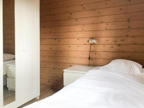 斯欣费尔德Holiday Home De Brenkberg-1的一间卧室设有木墙、一张床和一盏灯