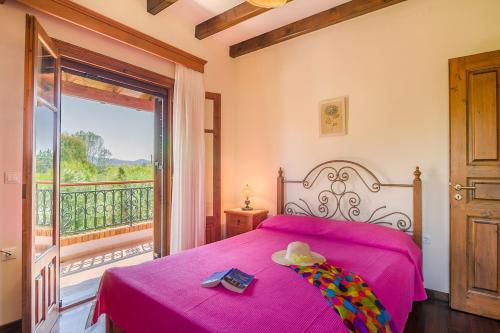 斯达林Villa Emilia的卧室配有粉红色的床和阳台。