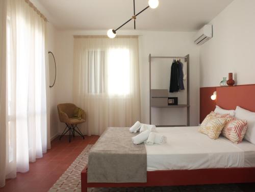 法维尼亚纳Casa Maja rooms & suites的一间卧室配有一张大床和一把椅子