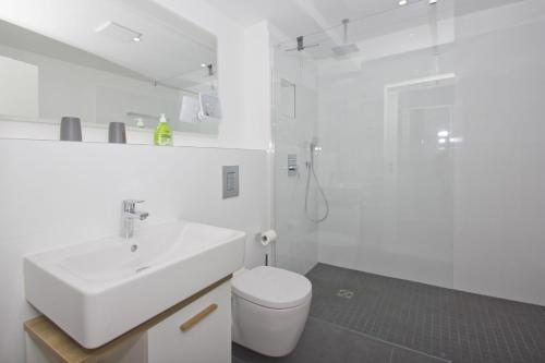 格罗斯齐克Ferienwohnung mit Meerblick und Gartennutzung - Haus Inselwind FeWo MEERstrand的白色的浴室设有水槽和卫生间。