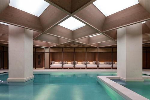伦敦The Londoner的一座带大型天花板的建筑中的游泳池
