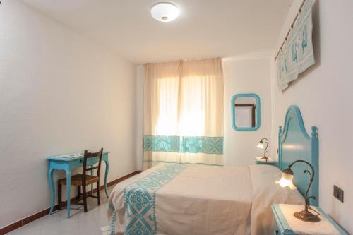 圣彼得罗镇Piccola casa Marina的一间卧室配有一张床、一张桌子和一个窗户。