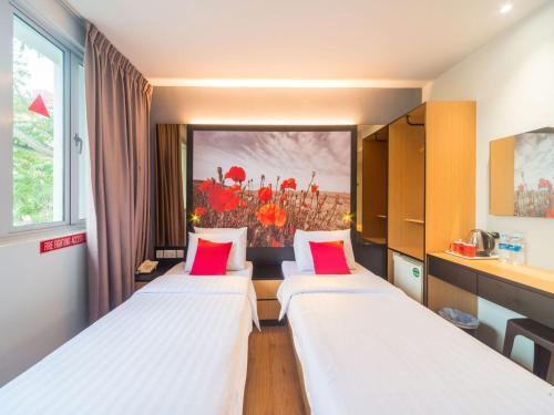 新加坡Hi Hotel Dot的带红色枕头的三张床