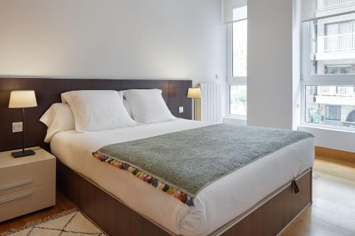 圣塞瓦斯蒂安Eder 1 by FeelFree Rentals的一间卧室设有一张大床和两个窗户。