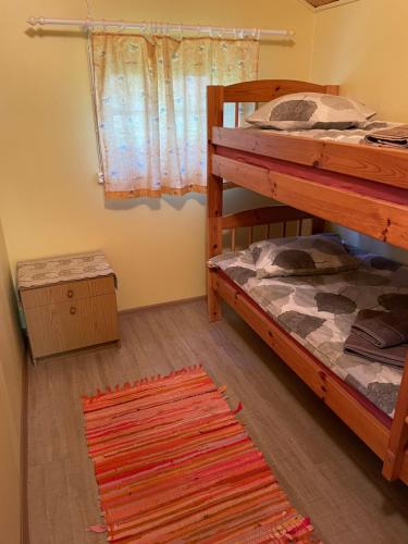 NõvaMetskonna Forest House的卧室配有两张双层床和地毯。