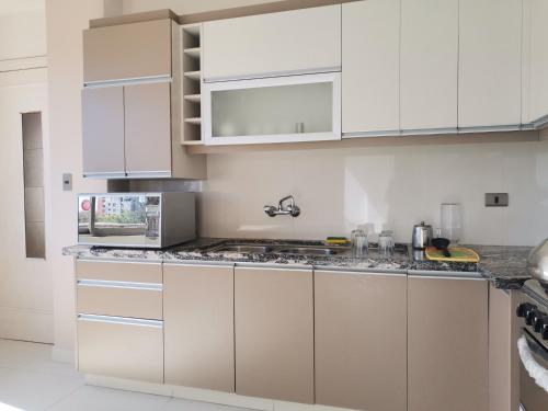 科恰班巴Hostal Costa De Marfil Suites & Apartamentos的厨房配有白色橱柜和花岗岩台面