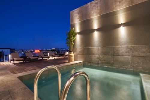 里斯本马尔克斯波尔图湾度假酒店 的夜间酒店屋顶的游泳池