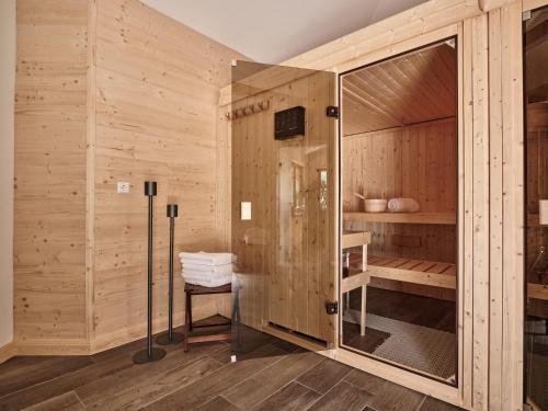 伦茨基希Hotel Hochfirst的一间带木墙和玻璃淋浴间的桑拿浴室