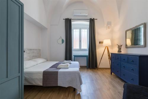 维拉诺瓦Casetta Mare的一间卧室配有一张床和一个蓝色梳妆台