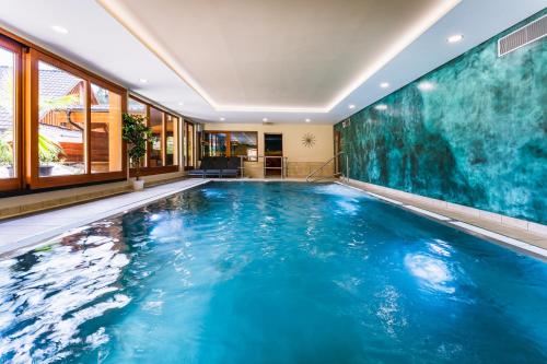 比拉Wellness Hotel Ondrášův dvůr的一座带大型蓝色游泳池的室内泳池