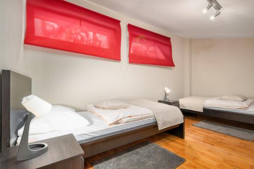 克拉平斯凯托普利采Apartmani Toplice的墙上有红色绘画的房间里,有两张床
