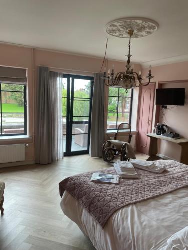 龙塞La Posterie的一间卧室设有一张大床和大窗户