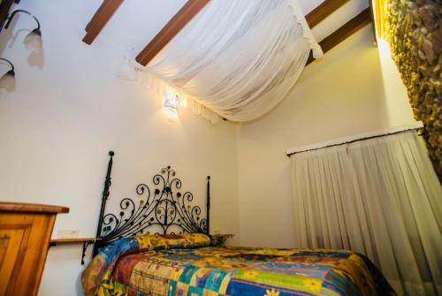 德尼亚Casita del Castillo的一间卧室配有一张带彩色毯子的床